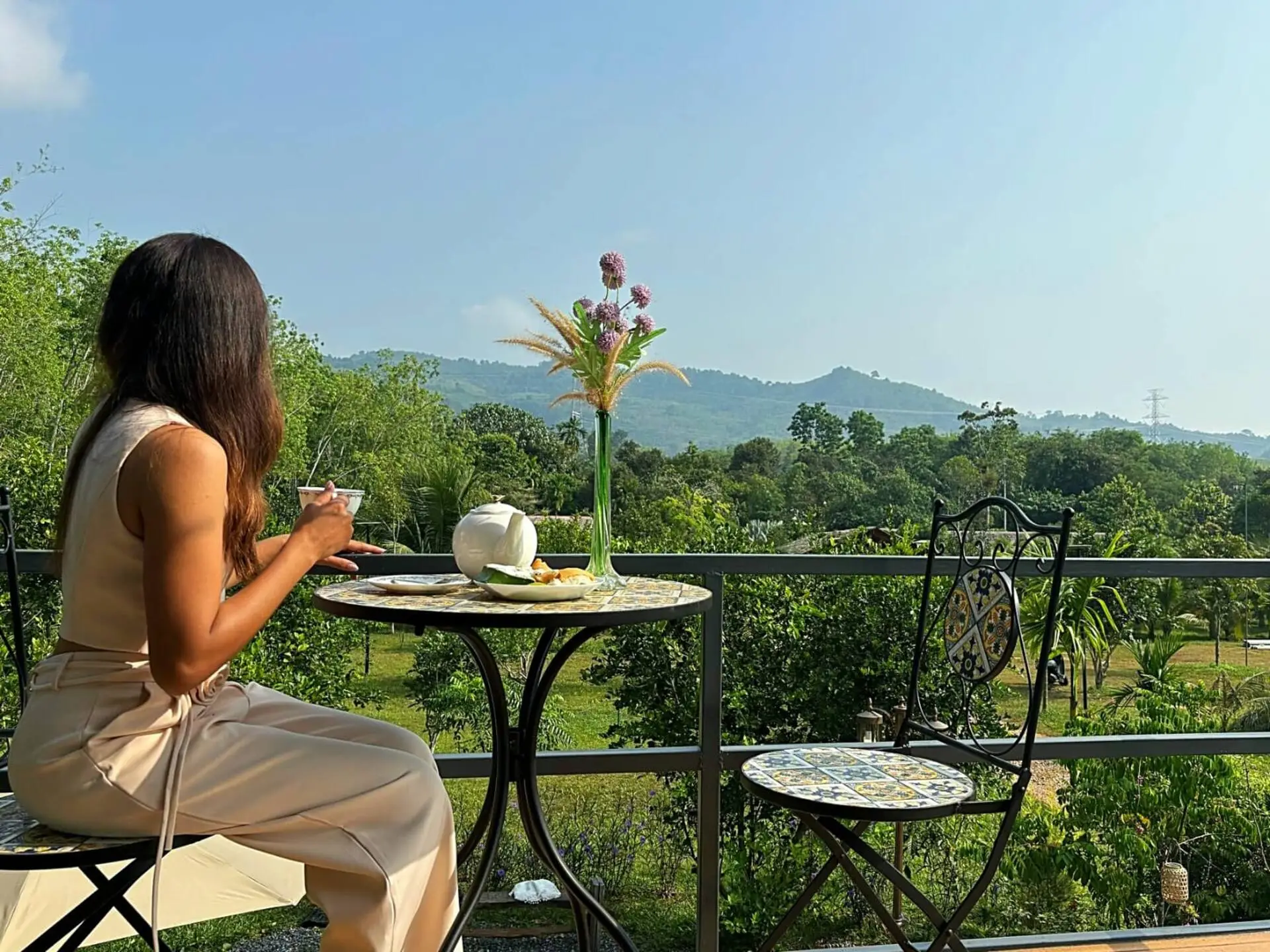 Guest enjoying morning tea on the balcony with mountain views at Uma Valley