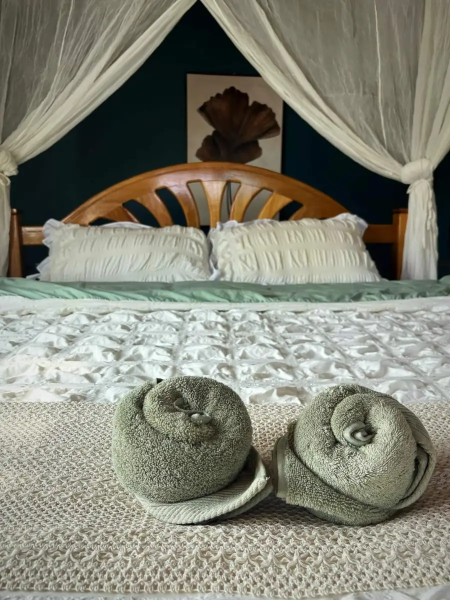 Folded towels on the canopy bed