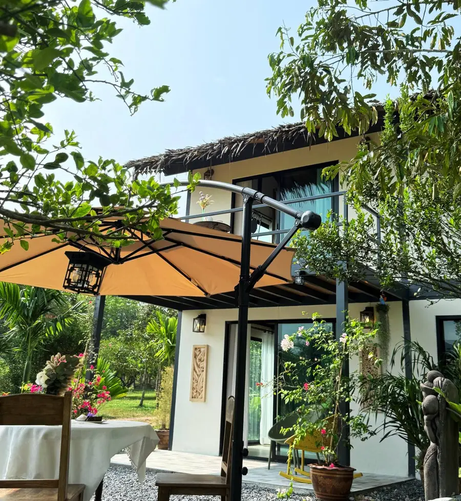 Garden terrace with parasol in front of the house